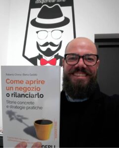 negoziante felice con il libro “Come aprire un negozio o rilanciarlo”