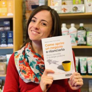 negoziante con libro “Come aprire un negozio o rilanciarlo”